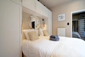 a bedroom with a large white bed with a mirror at L'Escapade in Liège