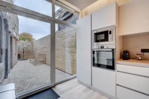 a living room with a large window and a kitchen at L'Escapade in Liège +23 photos
