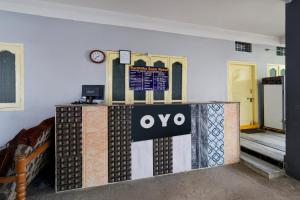 een kamer met een QO-bord aan de muur bij SPOT ON Harshitha Guest House in Pedda Ambarpet