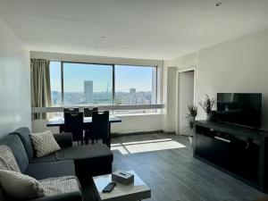 a living room with a couch and a table with chairs at Apartment Paris La Défense Eiffel Tower Skyline in Puteaux