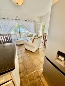 a living room with white furniture and a balcony at Beachfront Apartment in Tergniet