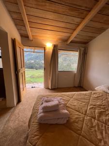 a bedroom with a large bed with a large window at Mamá Raywa in Huari
