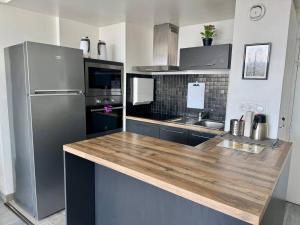 a kitchen with a refrigerator and a wooden counter top at Apartment Paris La Défense Eiffel Tower Skyline in Puteaux