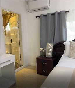a bedroom with a bed and a dresser with a mirror at Elilia in Beau Vallon