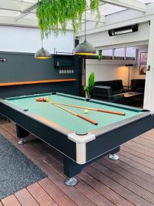 a pool table in a living room with a pool at OVERNIGHT No5 - Bungalow, Billard, Dart, Kamin in Hannover