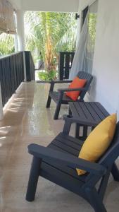 a row of blue benches sitting on a porch at Elilia in Beau Vallon