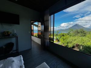 a room with a large window with a view of a mountain at Villa lago in El Castillo de La Fortuna