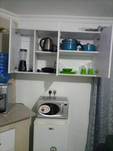 Una cocina con un microondas encima de una encimera. en The Karen Haven, en Nairobi