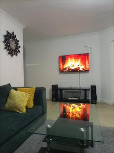 Una sala de estar con un sofá y una chimenea. en The Karen Haven, en Nairobi