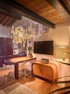 a kitchen with a table and a tv on the wall at Cognaia Loft in Arezzo +6 photos