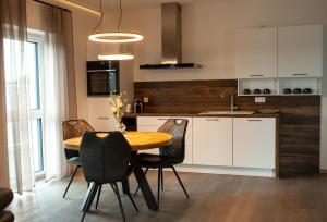 a kitchen with a wooden table and black chairs at Deluxe Apartment-Fürstenau 3 in Fürstenau