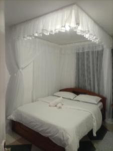 Un dormitorio con una cama blanca con dosel. en The Karen Haven, en Nairobi