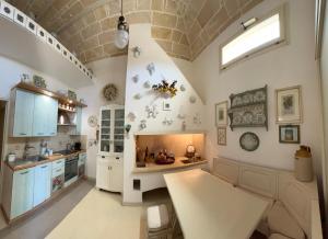 a kitchen with white cabinets and a ceiling with a window at Tramonto in Santa Maria al Bagno +16 photos