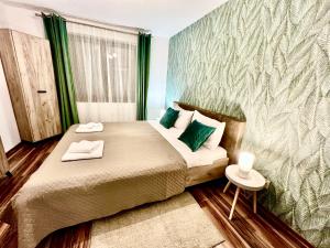 アヴリグにあるS-HOUSE Apartament spatios cu 2 dormitoare, curte, bucatarie, terasă și parcare privată aproape de Sibiuの小さなベッドルーム(緑の枕が付くベッド付)