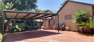 センチュリオンにあるLily's Innの家の前の歩道上のパーゴラ