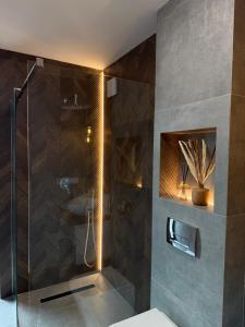 ein Badezimmer mit Dusche mit Glastür in der Unterkunft Domivka котедж із чаном-джакузі, каміном і кіно-зоною у Cлавську in Slawske + 12 Fotos