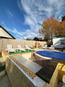 a swimming pool with lounge chairs and a fence at Brick House in Kragujevac