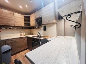 eine Küche mit Holzschränken und einer Arbeitsplatte in der Unterkunft Apartament w sercu Karkonoszy in Jelenia Góra + 17 Fotos