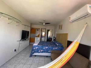 a bedroom with a bed and a hammock in it at Apartamento amplo e confortavel in Cabedelo