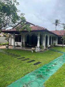a house with a pond in the yard at Dona's Villa, Coastal Tropical House in Kepungoda