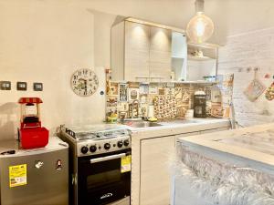 a kitchen with a stove and a sink at Apto-Hotel Villa de Leyva Flor de María con Terraza in Villa de Leyva +4 photos