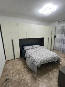 a bedroom with a bed and white cabinets at Relax suite in Alessandria