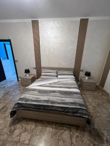 a bedroom with a large bed with two night stands at Relax suite in Alessandria +5 photos