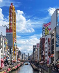 桜の宿 في أوساكا: نهر في مدينة ذات مباني شاهقة وقناة