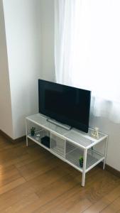 桜の宿 في أوساكا: تلفزيون بشاشة مسطحة جالس على مركز ترفيه ابيض