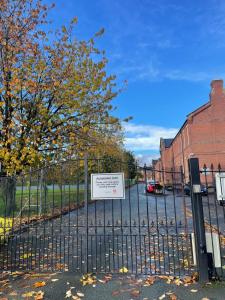 un cartel en una valla delante de un edificio en Arti One Bedroom Apartment, en Wrexham
