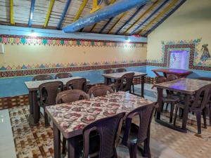 a restaurant with tables and chairs and a mural on the wall at White Land Villagestay in Dhordo