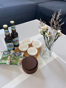 una mesa con cerveza y aperitivos y un jarrón de flores en Arti One Bedroom Apartment, en Wrexham 2 fotos más