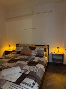 a large bed in a room with two lamps on tables at Hypogeon Residence in Bitola