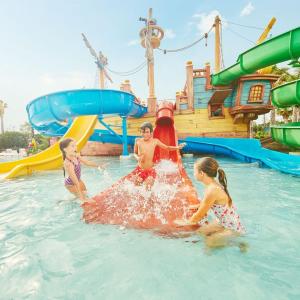drei Kinder spielen im Wasser in einem Wasserpark in der Unterkunft House in front of the beach in Cambrils