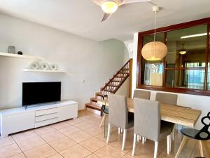 ein Wohnzimmer mit einem Esstisch und einem TV in der Unterkunft House in front of the beach in Cambrils