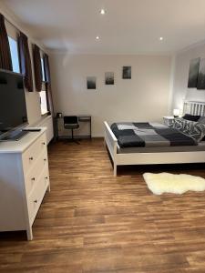 BadbergenにあるModerne Ferienwohnung mit Fachwerkcharmeのベッドと薄型テレビのある寝室