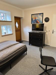 BadbergenにあるModerne Ferienwohnung mit Fachwerkcharmeのベッドルーム(ベッド1台、ドレッサー内のテレビ付) +15枚の写真