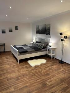 BadbergenにあるModerne Ferienwohnung mit Fachwerkcharmeのウッドフロアのベッドルーム1室(ベッド1台、ラグ付)