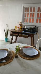 a table with two plates and a table with a stove at Pousada Natureza in Cabo Frio