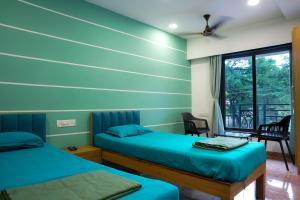 ダポリにあるHotel Royal Usiのベッドが2つと窓のある部屋