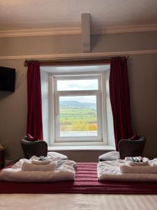 een kamer met 2 stoelen en een raam bij Three Wheat Heads in Thropton