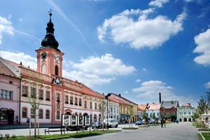 a building with a clock tower on a street at Penzion Bezděkov in Rakovník