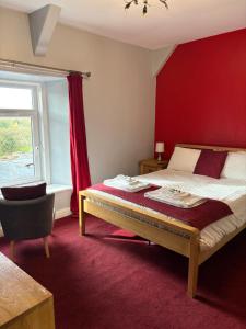 een slaapkamer met een bed en een rode muur bij Three Wheat Heads in Thropton