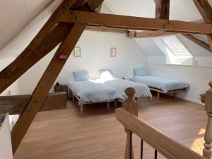 two beds in a attic room with wooden beams at Le Cottage - maison de 6 à 8 personnes - La Ferme du Try in Frasnes-lez-Gosselies