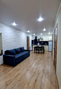 a living room with a blue couch and a table at Морской бриз in Aktau