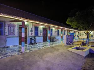 a building with a courtyard at night at White Land Villagestay in Dhordo