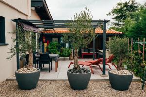 a patio with trees and a table and chairs at La Grange in Sablons