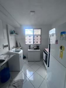 une petite cuisine avec un réfrigérateur et un évier dans l'établissement Viver Melhor Apartment, à Marituba