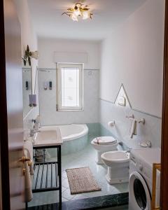 Un baño con bañera, inodoro y lavabo. en Gli Agrumi di nonna Peppina - Appartamento Arance, en Mondragone 21 fotos más
