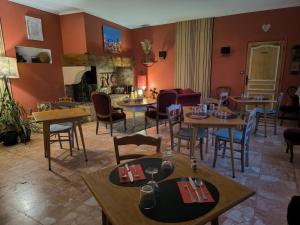 a restaurant with tables and chairs and a fireplace at Auberge de l'Escargot d'Or in Dieulefit +52 photos